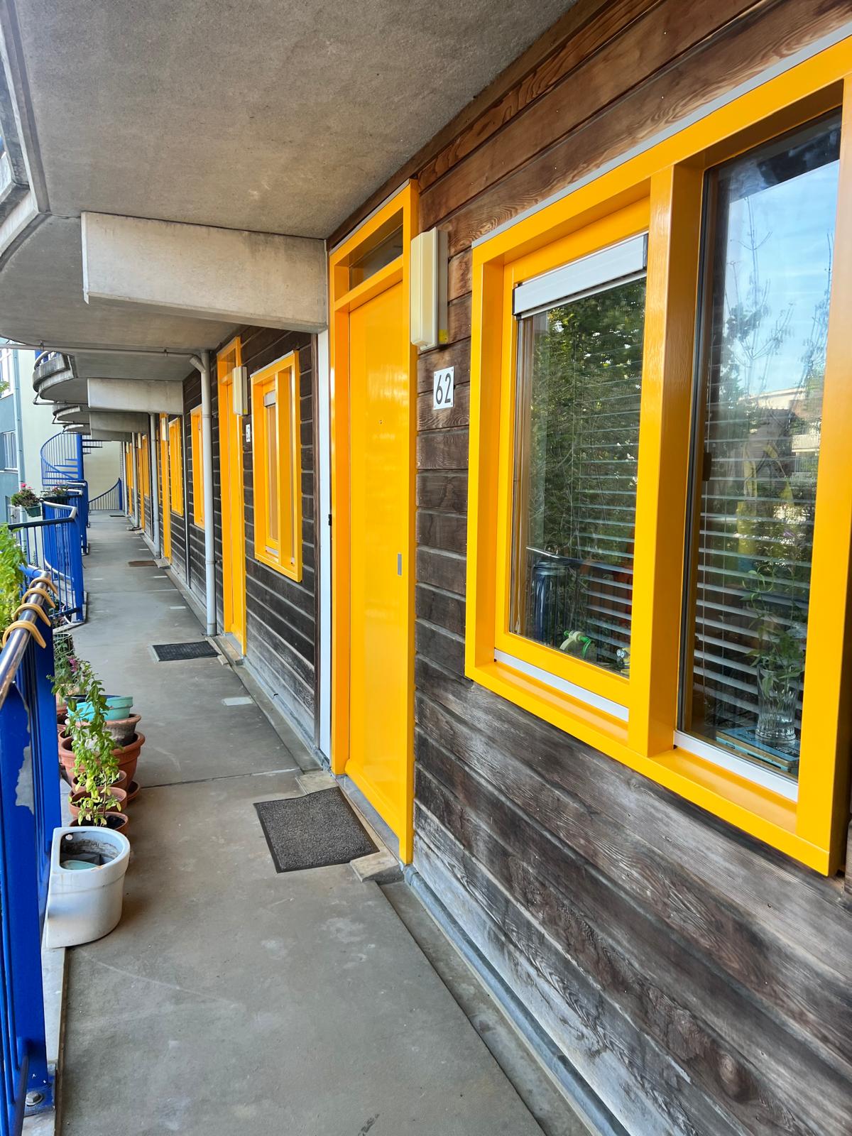 Galerij van een appartementencomplex met geschilderde kozijnen en deuren