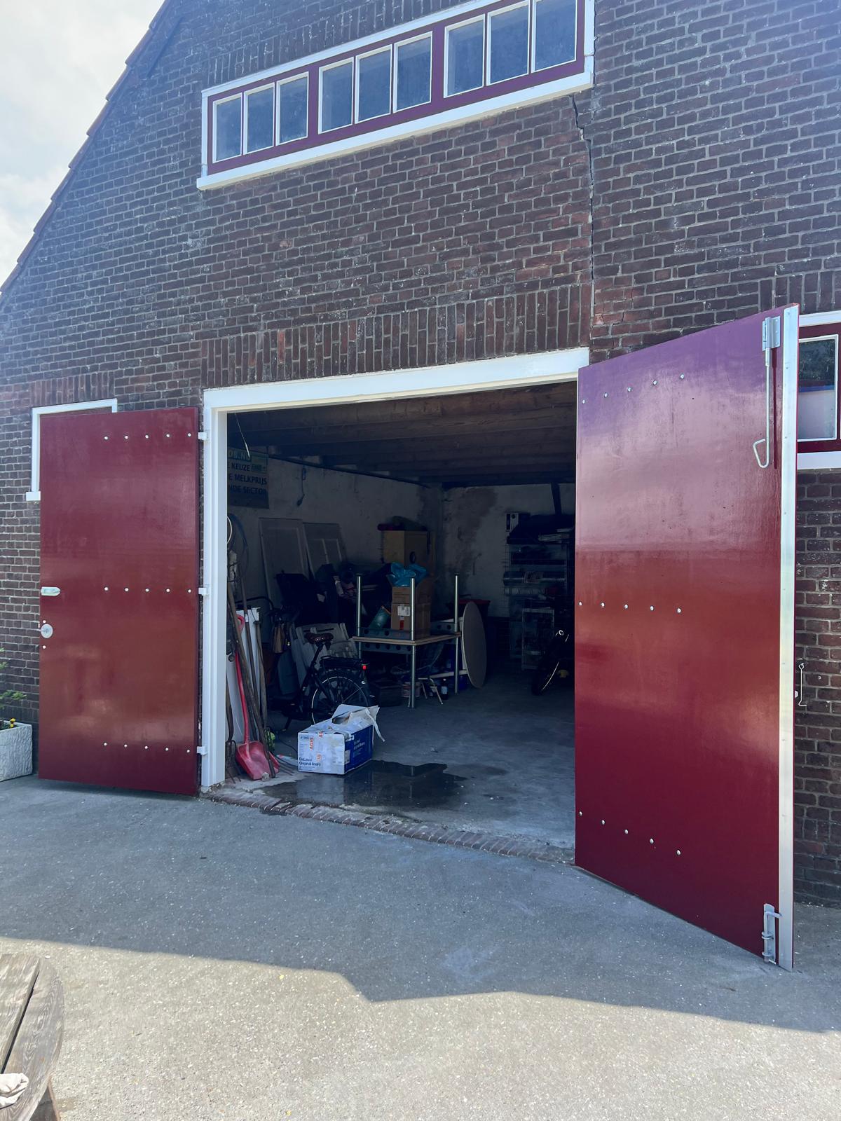 Grote houten deuren geschilderd tijdens een renovatieproject