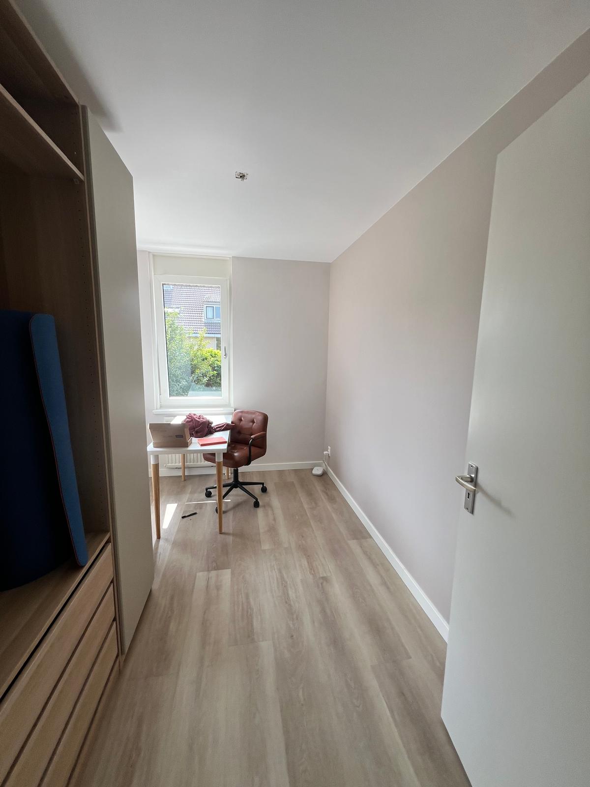 Kleine kamer met strak geschilderde wanden en plafond