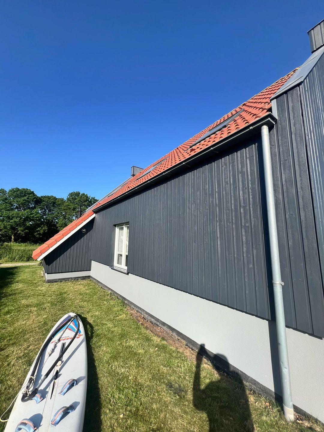 Geschilderde buitengevel en houten terras van villa in Zoetermeer