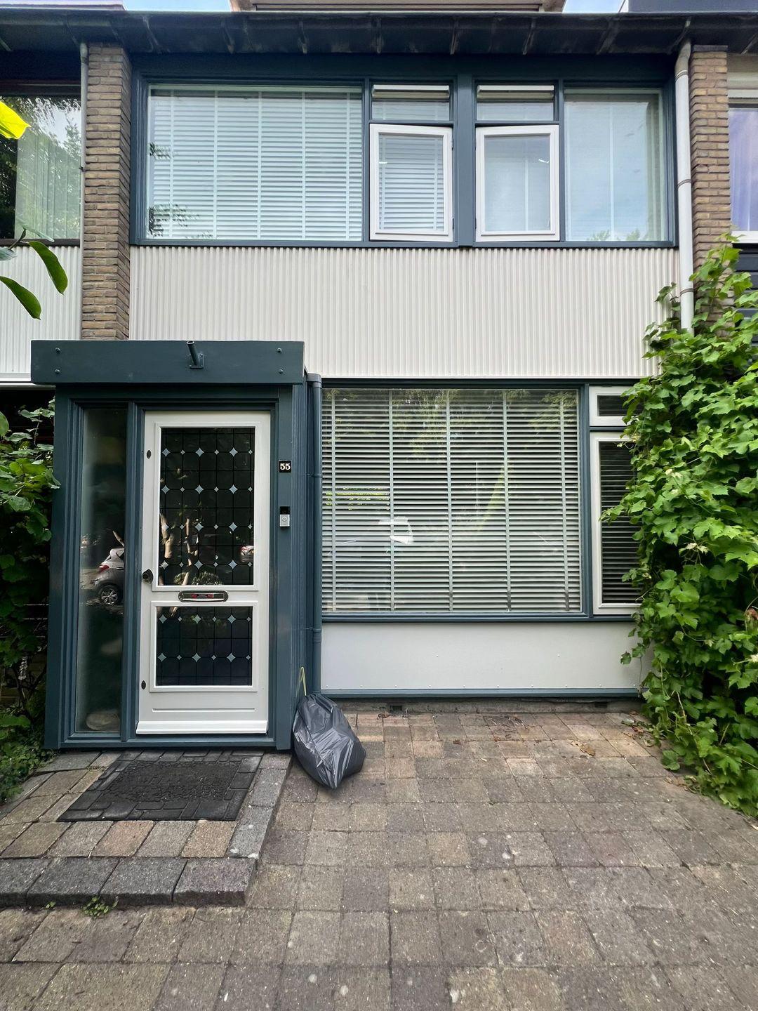 Voorgevel met geschilderde kozijnen en ramen na buitenschilderwerk